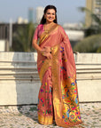 Woman wearing a traditional saree with a colorful design outdoors.