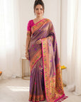 Woman wearing a traditional saree with a purple and pink design in a minimalistic setting.