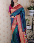 Woman wearing a colorful saree indoors with decorative elements.