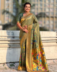 Woman in a traditional saree with floral patterns standing outdoors.
