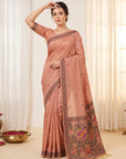Woman wearing a traditional saree with intricate patterns in a well-lit room.