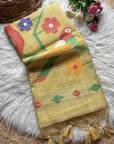 Yellow fabric with colorful floral and parrot designs on a textured surface.