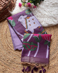 Purple scarf with a white rabbit design on a textured surface with flowers and a basket.