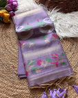 Folded purple fabric with floral patterns on a textured surface