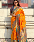 Woman wearing an orange saree with a cityscape in the background