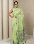 Woman wearing a light green saree with a beige background