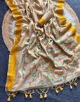 Beige fabric with floral patterns and yellow border on a blue background