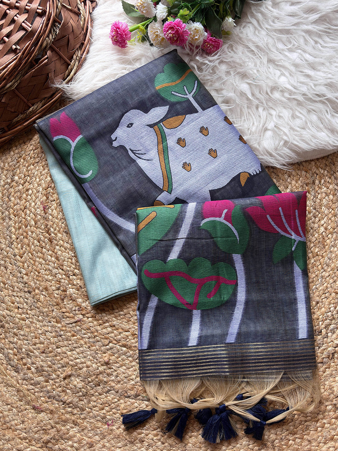 Two patterned scarves with animal and plant designs on a textured surface.