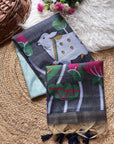 Two patterned scarves with animal and plant designs on a textured surface.