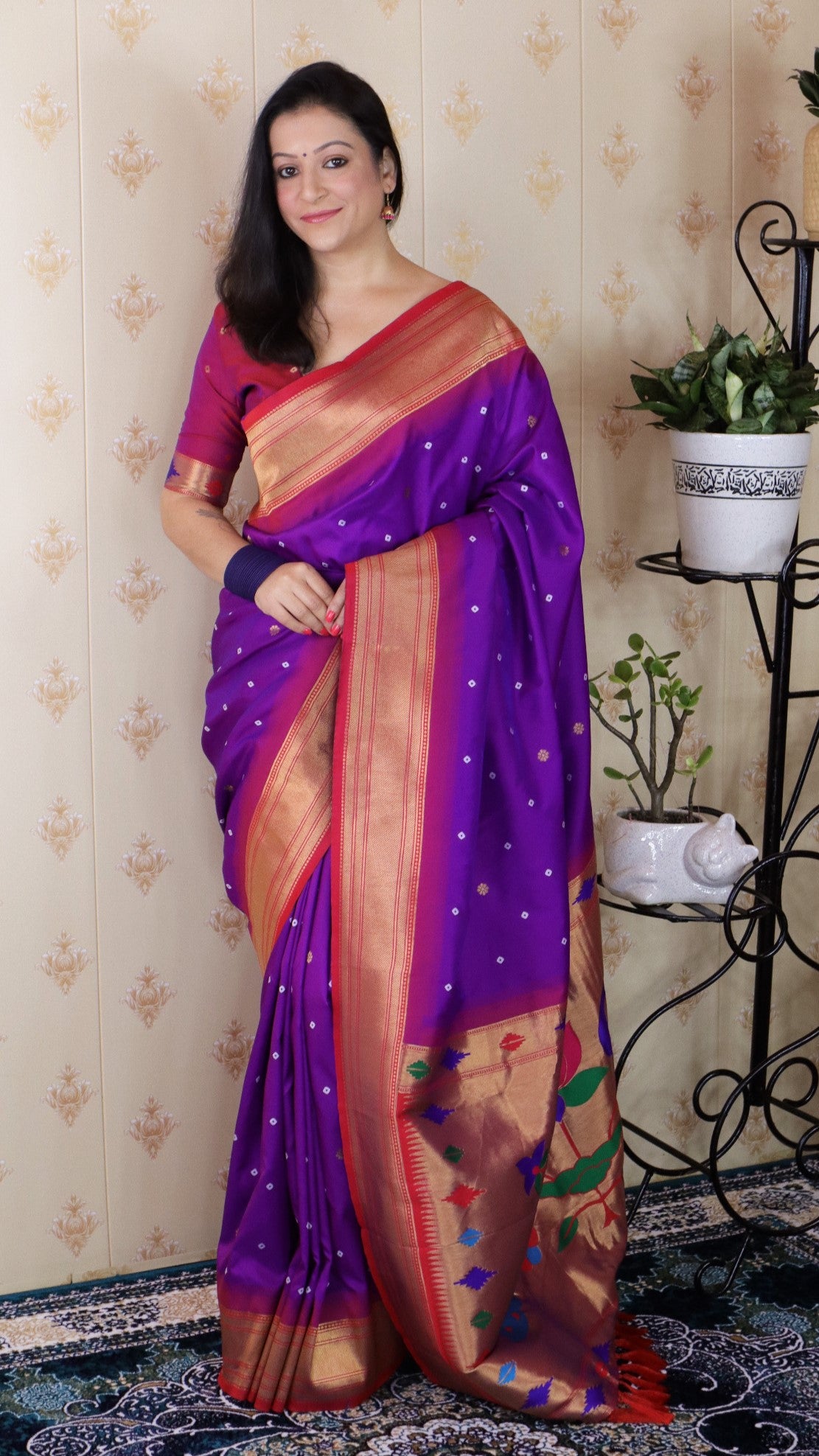 Woman wearing a purple saree with a patterned background