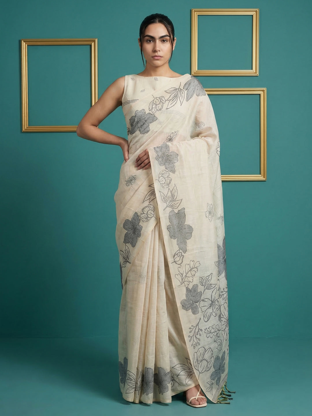 Woman wearing a floral saree against a teal background with gold frames.