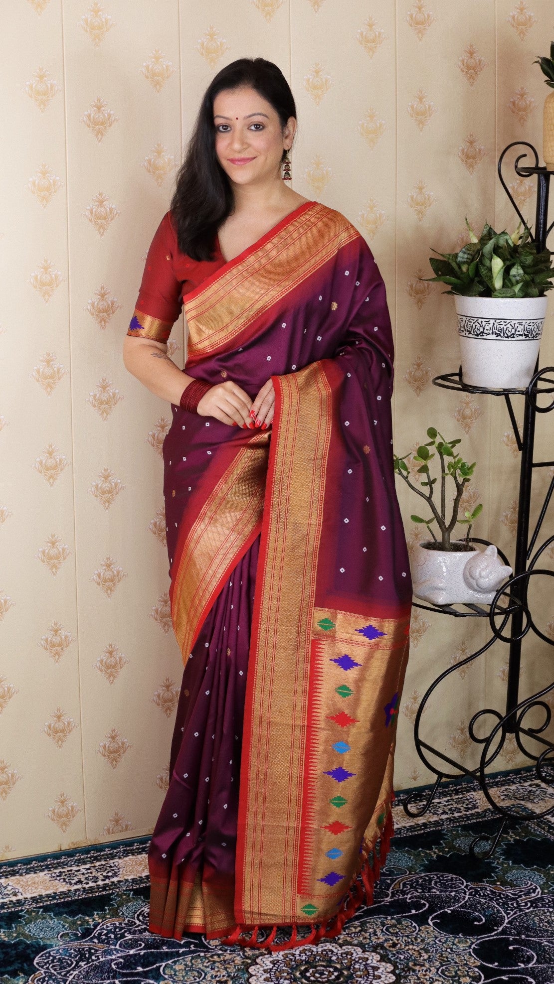 Woman wearing a traditional saree in a room with decorative elements.