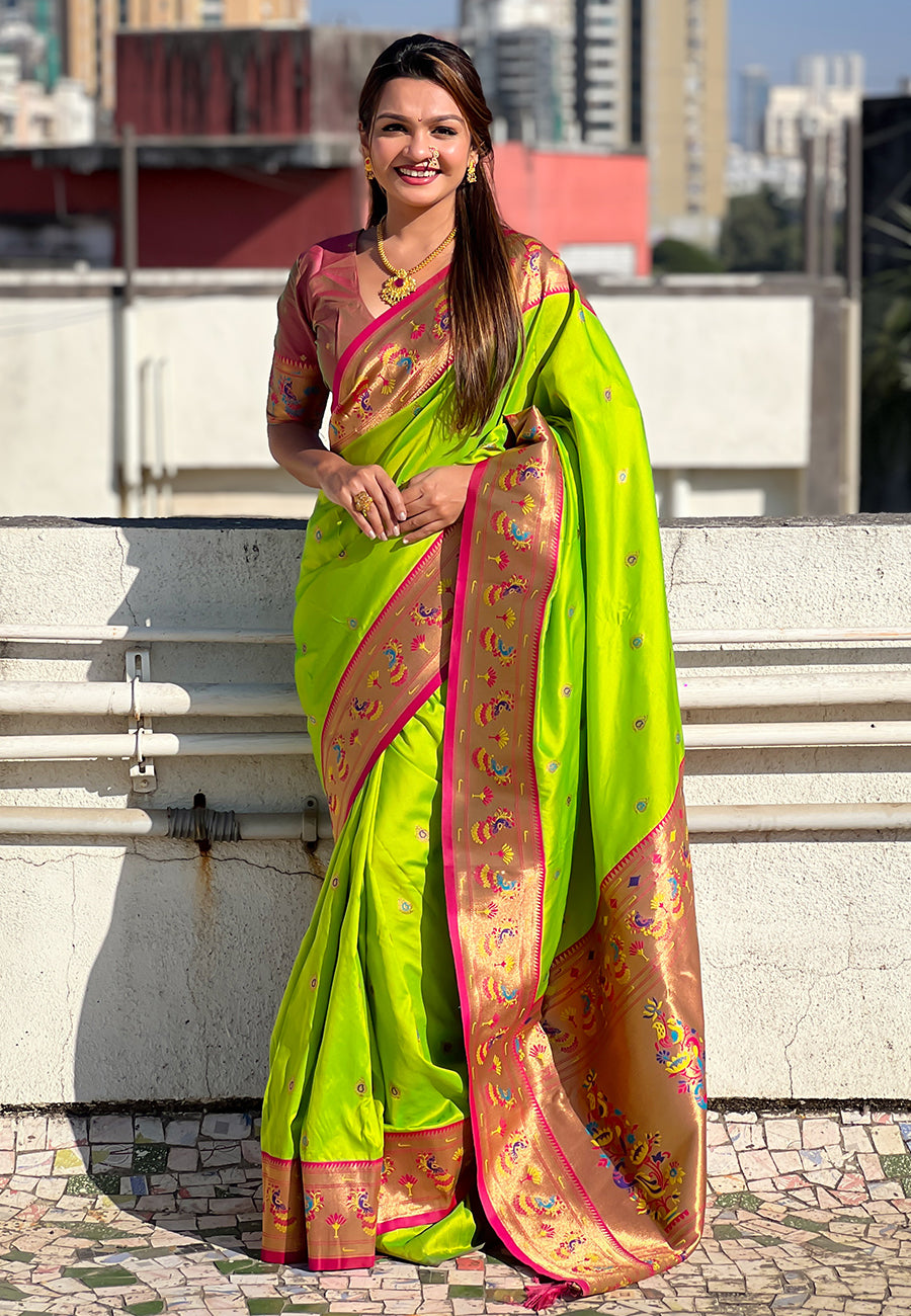Woman wearing a bright green saree with a pink border on a rooftop.