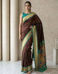 Woman wearing a brown and green saree with a neutral background