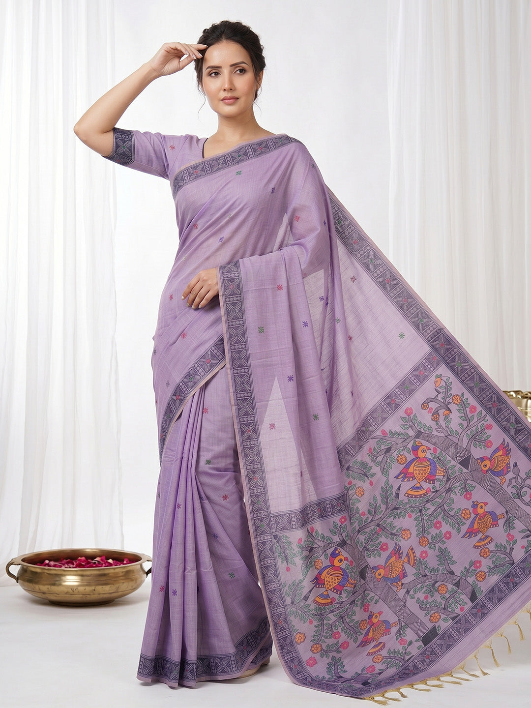 Woman wearing a purple saree with a floral border on a white background