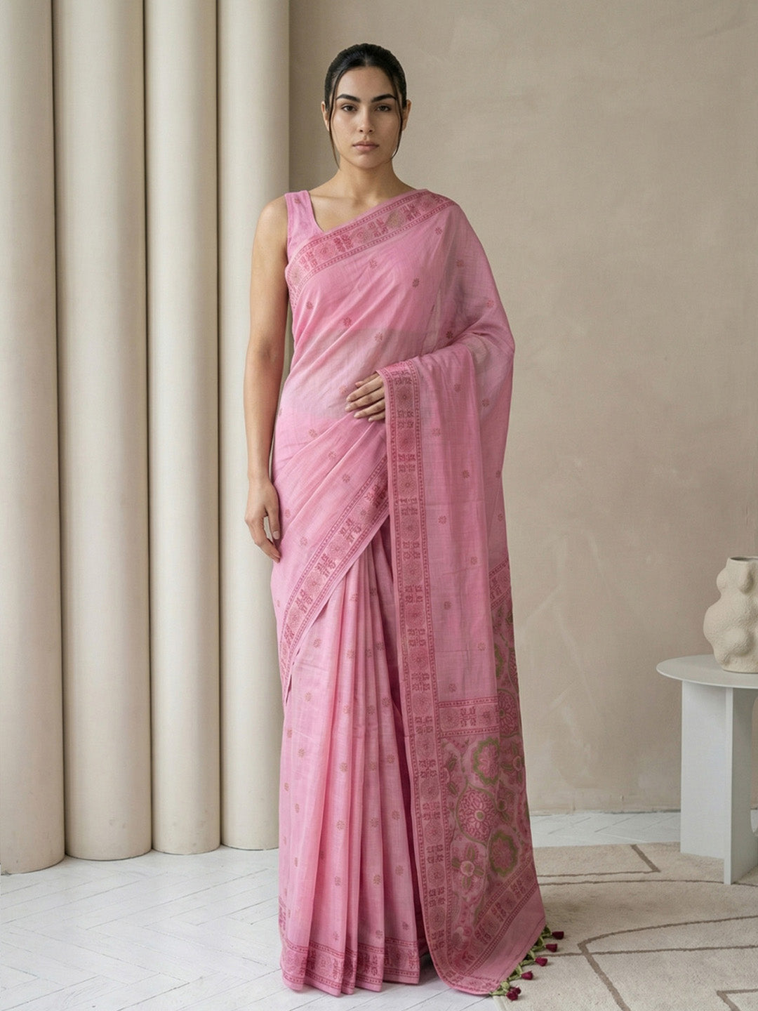 Woman wearing a pink saree with a neutral background