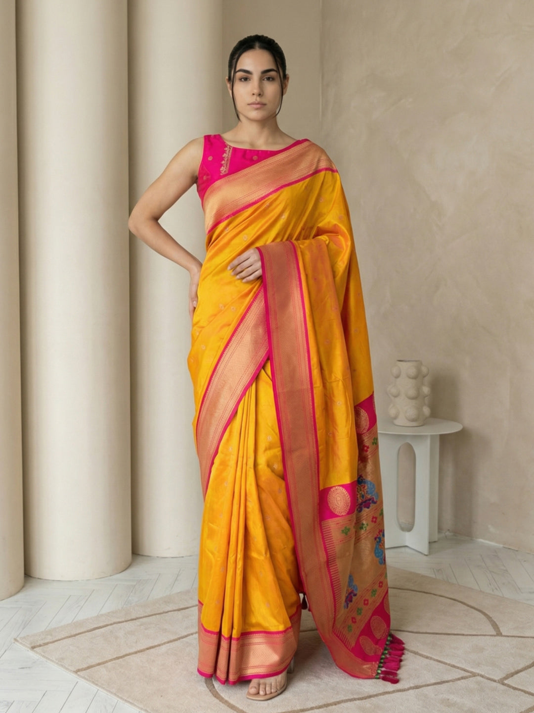Woman wearing a yellow saree with pink border indoors