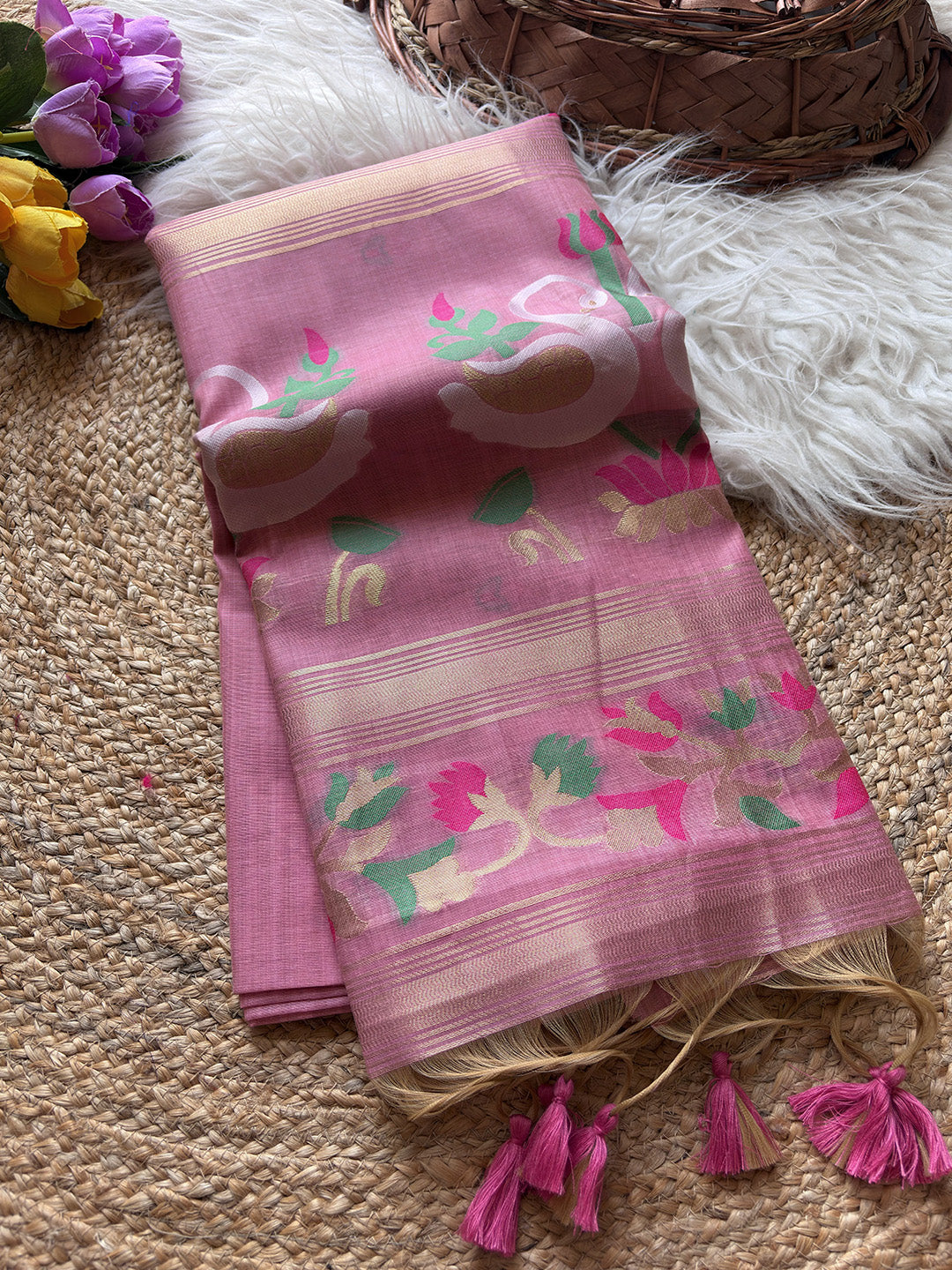 Pink saree with floral patterns on a textured surface