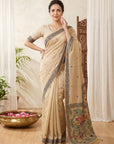 Woman wearing a beige saree with floral patterns indoors