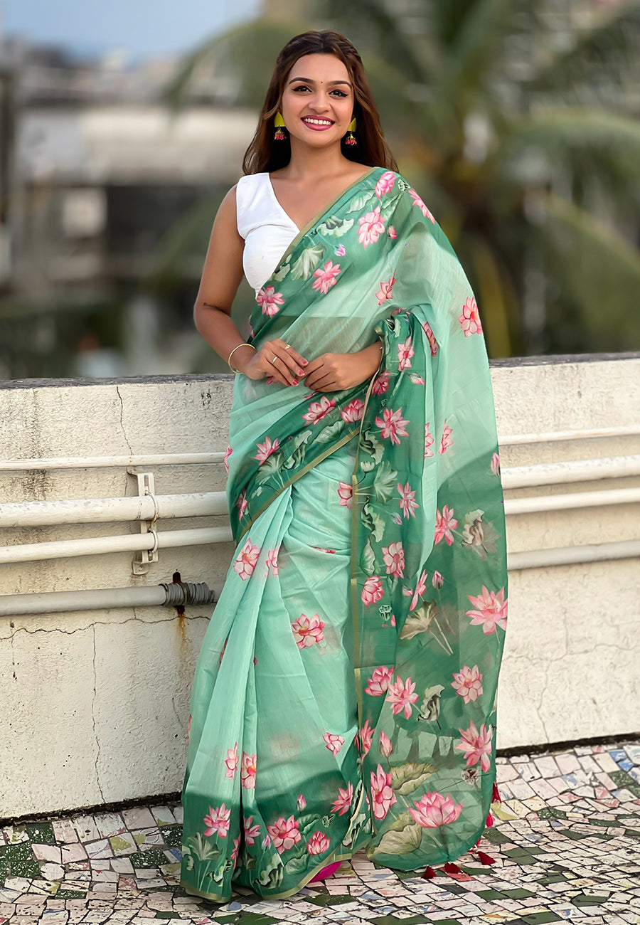 Woman wearing a green floral saree with a blurred background