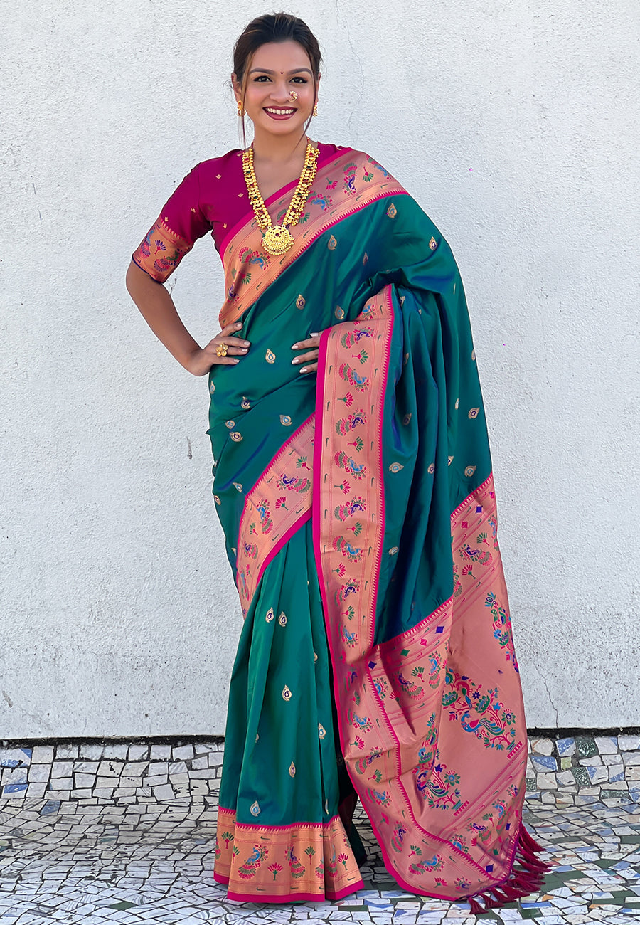 Woman wearing a green and pink saree with a white background