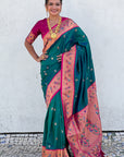 Woman wearing a green and pink saree with a white background
