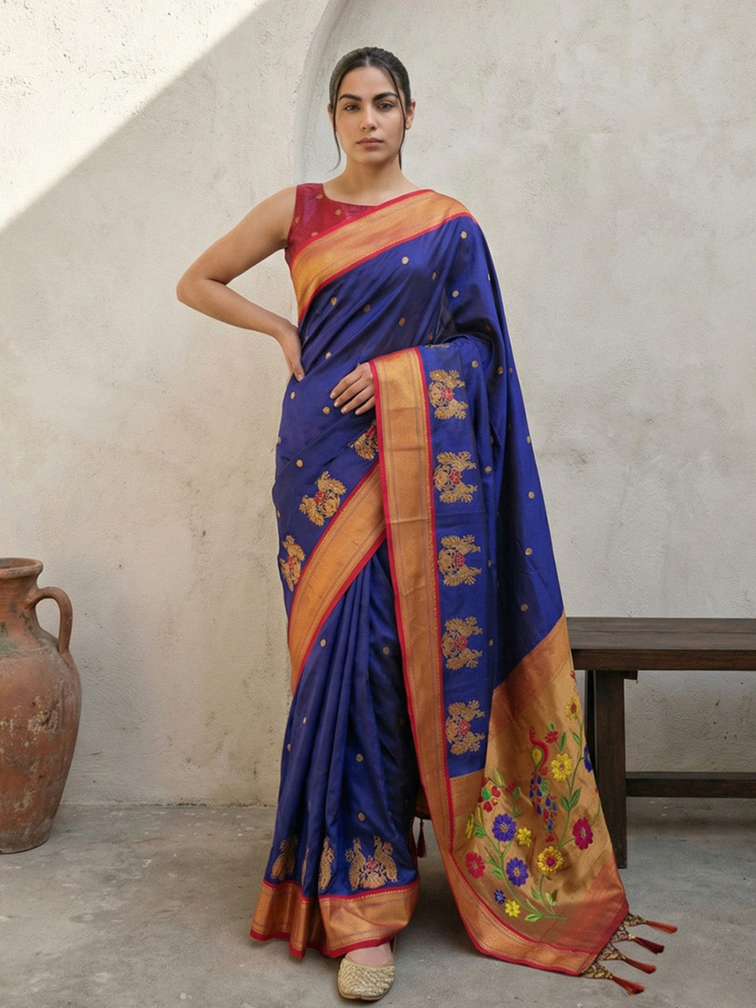 Woman wearing a blue saree with floral patterns in an indoor setting