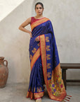 Woman wearing a blue saree with floral patterns in an indoor setting