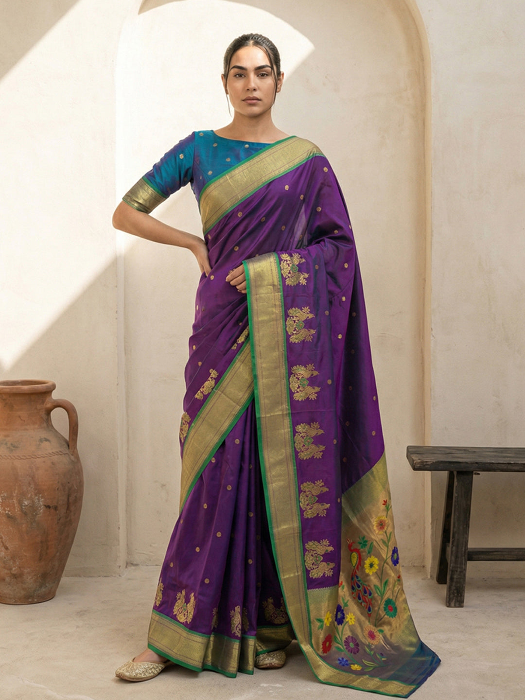 Woman wearing a purple saree with gold border in a room setting