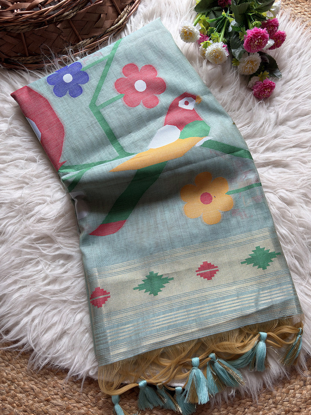 Decorative fabric with parrot and flower patterns on a fluffy white surface.