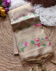 Beige scarf with floral patterns on a textured surface with flowers and a basket in the background